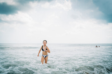 portrait of an asian girl playing at the beach in summer