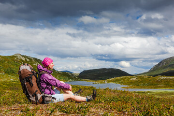 Woman Traveler with Backpack have a rest in the mountains