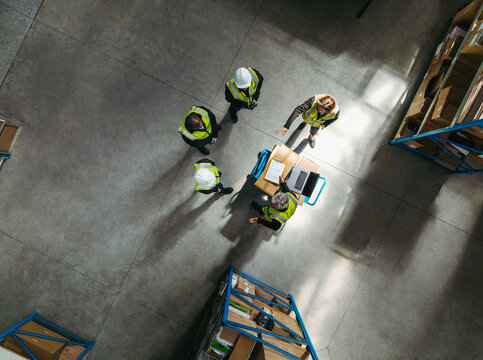 Overheard view of a warehouse team having a discussion during a meeting