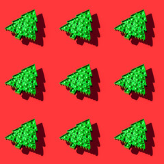 Isometric seamless pattern of green kids anti stress pop it toy in form of Christmas tree on red.
