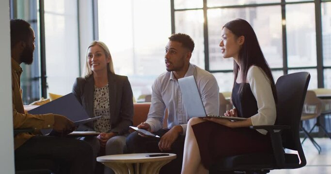 Video of happy diverse colleagues in discussion at informal office meeting at sundown