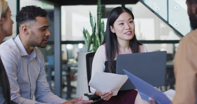 Video of asian businesswoman talking to diverse colleagues at office meeting
