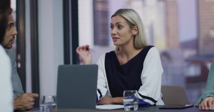 Video of caucasian businesswoman talking to colleagues at office meeting