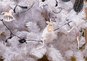 Fragment of a white artificial Christmas tree with different New Year decorations. Horizontal...