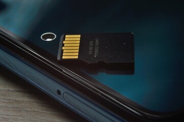 micro sd card lies on the smartphone screen. close-up