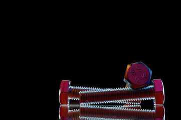 composition of bolts and nuts of different sizes on a black background
