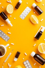 Illness concept. Top view vertical photo of remedy spray and syrup bottles pills blisters...