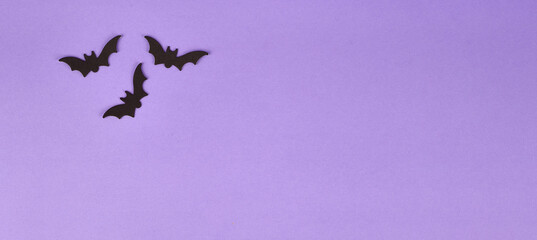 Fototapeta premium Halloween decorations, pumpkins, on violet background. Halloween party greeting card. Copy space. Flat lay, top view, overhead.