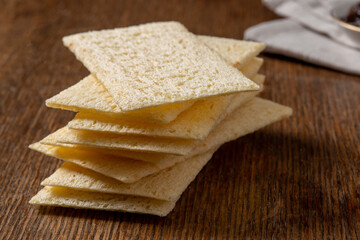 A stack of crunchy crisp bread on a wooden worktop.