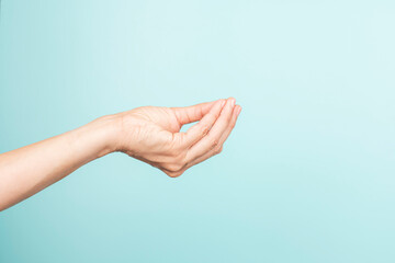 Italian hand gesture. Woman hand Italian gesture on light blue background. Front view, copy space