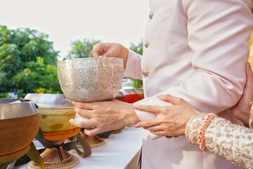 groom and bride make merit in the Thai Buddhist style wedding ceremony and Thai wedding ceremony.        