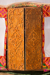 Carved wooden patterns of Asia. National traditional decoration of yurt furniture in ornament vintage weaving patterns, decoration of yurt wooden frame with patterns as ethnicity. Yurt doors.