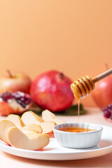 Closeup of plate with apples and honey for Jewish holiday Rosh Hashanah