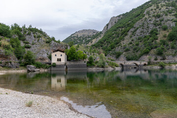 Fototapeta na wymiar Lake of San Domenico in Abruzzo, Italy and the Eremo di San Domenico in the background.