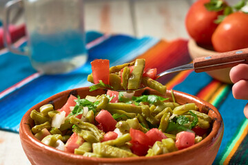 Traditional mexican nopal cactus salad or nopales a la mexicana. Vegan food.