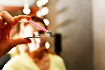 defocused woman holding and showing nail clipper to front in bathroom at home or hotel - obrazy, fototapety, plakaty