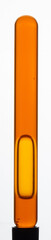 Yellow viscous liquid sunflower lecithin with bubbles in a transparent test tube on a white background