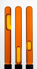 Yellow viscous liquid sunflower lecithin with bubbles in a transparent test tube on a white background