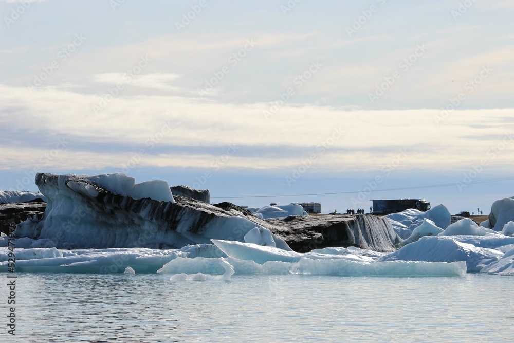 Sticker white icebergs in the middle of an ocean on a sunny day