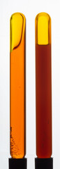Yellow viscous liquid sunflower lecithin with bubbles in a transparent test tube on a white background