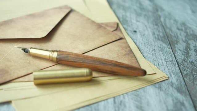 envelope , empty paper and fountain pen on table 