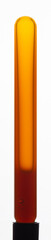 Yellow viscous liquid sunflower lecithin with bubbles in a transparent test tube on a white background