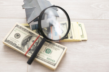dollar, toy house next to a magnifying glass, sale of real estate, rental housing
