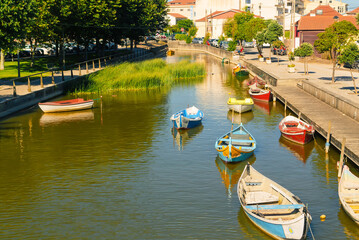 Fototapeta na wymiar Fishing boats at the pier on the river. River channel in the evening in the countryside