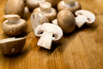 Fresh champignons mushrooms on wooden cutting board