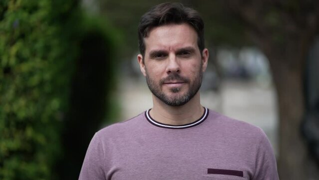 One happy motivated handsome walking forward toward camera outdoors. Smiling male person walks walks in street