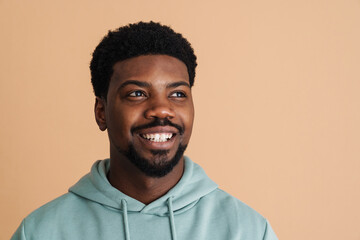Black young man wearing hoodie smiling and looking aside
