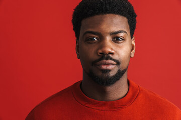 Black young man wearing hoodie posing and looking at camera