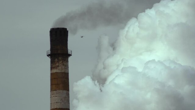Smoke coming out of an industrial chimney of a chemical plant. Air pollution and global warming.