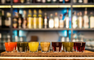 Colourful set of alcoholic cocktails in shot glasses shooters for an alcoholic party. Set of different colorful natural fruit alcoholic tinctures