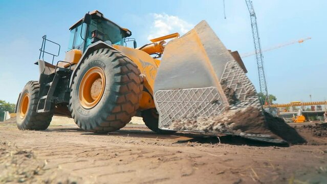 Yellow tractor on a construction site. Professional construction equipment. Work process at a construction site