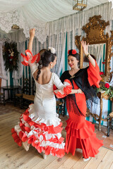 Hispanic women dancing Sevillanas in tent