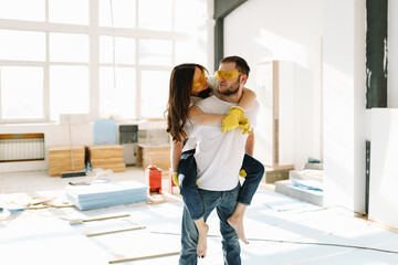 Happy newlyweds kissing and hugging are happy to move into a new house by taking out a mortgage. A...