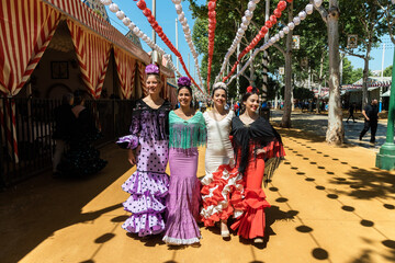 Graceful ethnic women in flamenco dresses in city street - obrazy, fototapety, plakaty