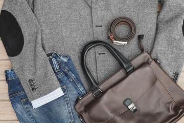 Top view blue jeans, leather bag and belt with grey tweed blazer. Casual business outlook. 