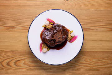 Stewed oxtail. Traditional Spanish tapa cooked with red wine and vegetables.