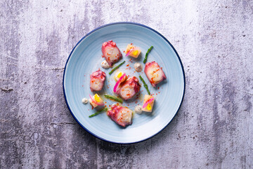 Octopus with potato, purple onion and paprika. Spanish modern tapa.