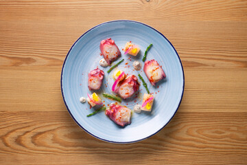 Octopus with potato, purple onion and paprika. Spanish modern tapa.
