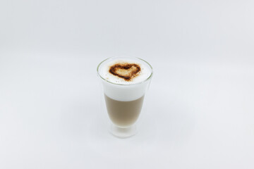 milk foam coffee, latte macchiato with chocolate powder heart shape on the foam, brown coffee in lower glass, white background, studio shot