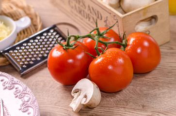 Close-up of fresh organic tomatoes and champignon mushroom on wood background. Bio Healthy food.