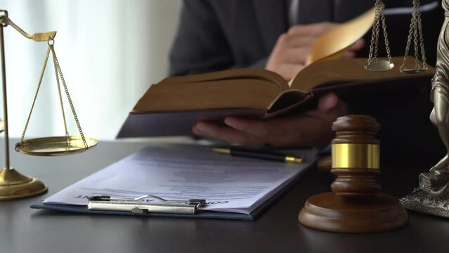 Close up lawyer man reading law book in office workplace for consultant lawyer concept.