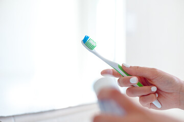 Woman hands holding toothpaste and toothbrush