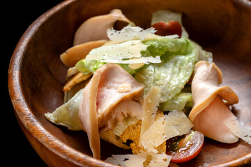 Caesar Salad with Grilled Salmon on wooden Plate Isolated. Salad with Red Fish Fillet, Mini Baguette Crackers.