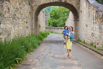 Mother and little handsome baby boy playing outdoor in old town.