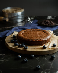 brownie cake on the wooden tray decorate with blueberry and black backdrop 