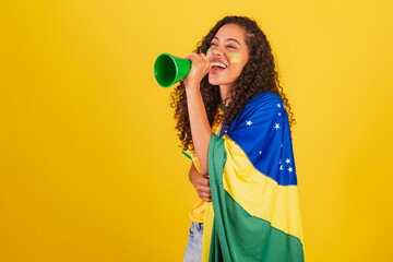 Young black Brazilian woman, soccer fan. screaming through loudspeaker. advertising photo.